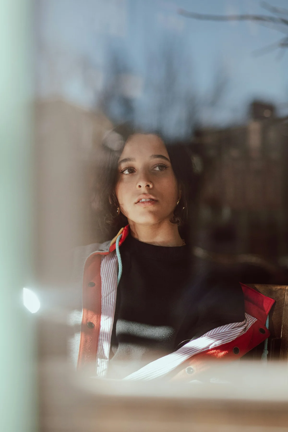 A young woman looking through a softly lit window