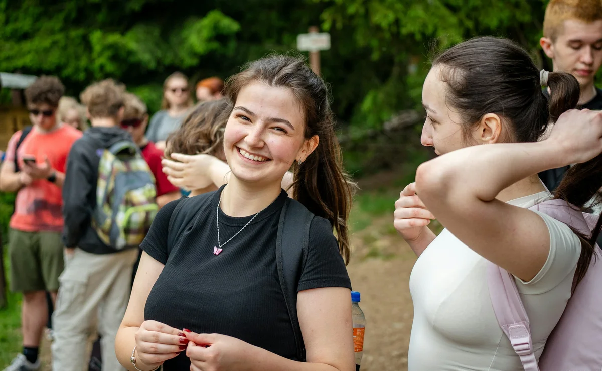 A young woman smiling among friends on a hike